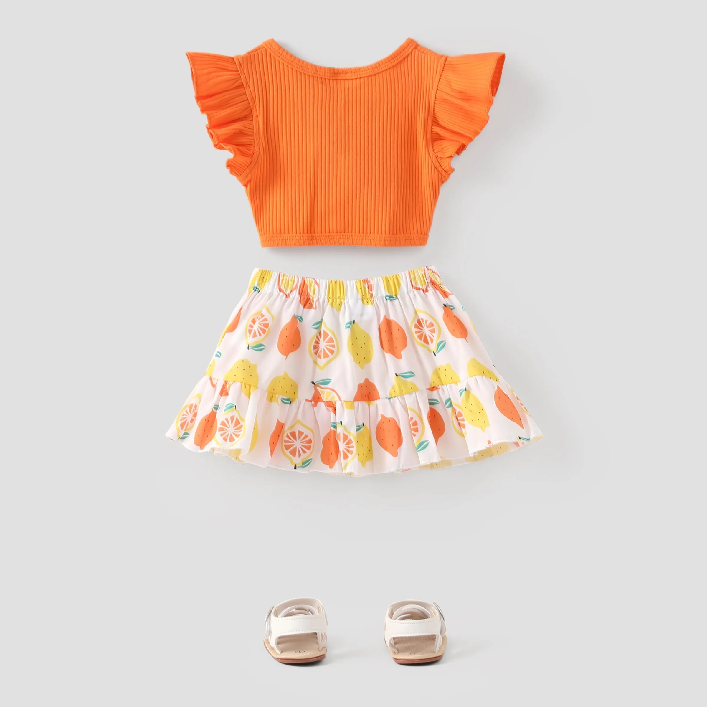 2pcs Baby Girl Solid Cotton Ribbed Ruffle-sleeve Twist Knot Crop Top and Allover Fruit Print Skirt Set