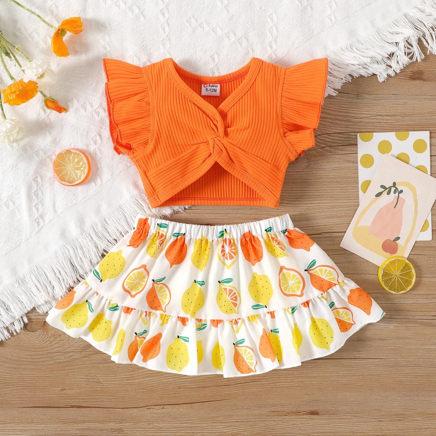 2pcs Baby Girl Solid Cotton Ribbed Ruffle-sleeve Twist Knot Crop Top and Allover Fruit Print Skirt Set